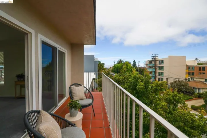Private balcony featuring terracotta tile flooring and a white metal railing