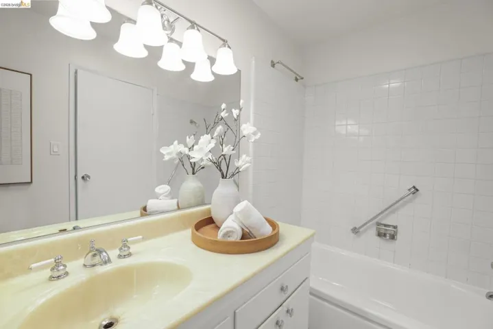 Bathroom vanity with a polished chrome faucet set, integrated sink, and white cabinetry