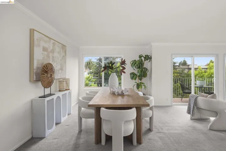 Spacious living area featuring carpet flooring, crown molding, and white baseboards