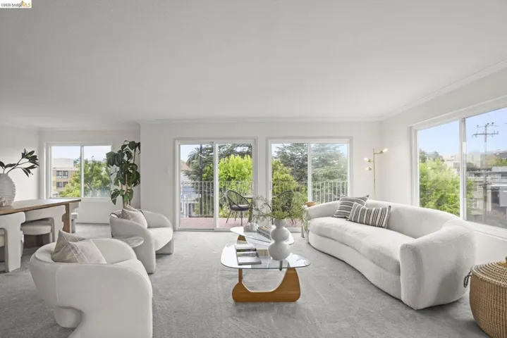 Spacious living area featuring light-colored carpeting and bright white walls