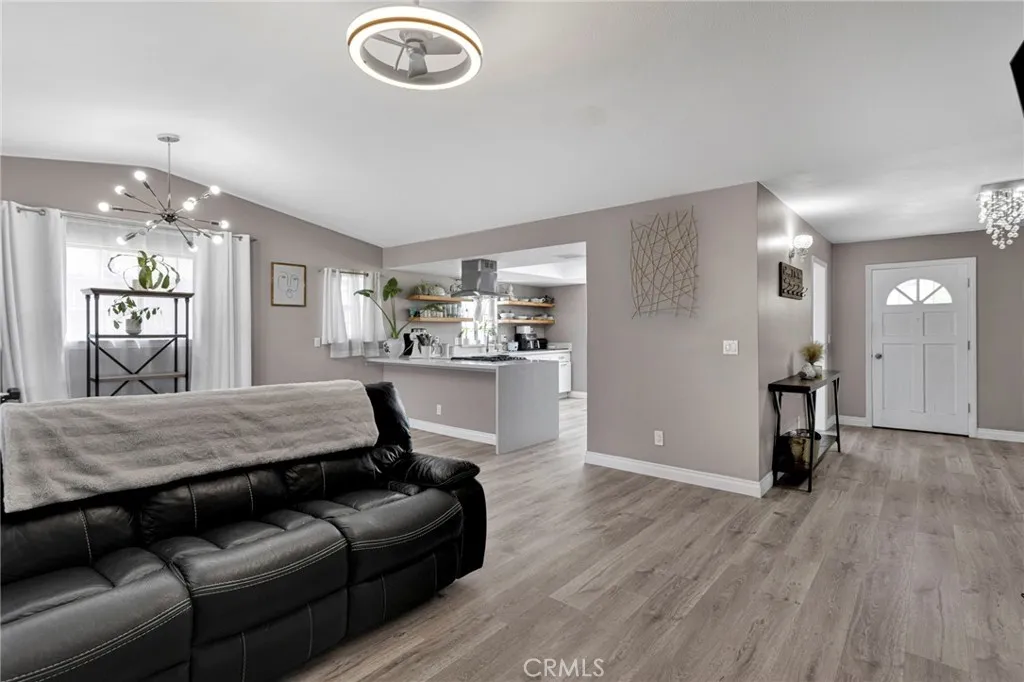 Open-concept layout showcases the seamless flow from the main living room directly into the kitchen peninsula workspace and front entry.