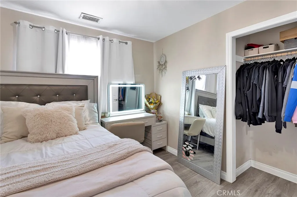 Alternate view of the bedroom layout accentuating the clean gray tones and smooth transition to the closet and hallway.