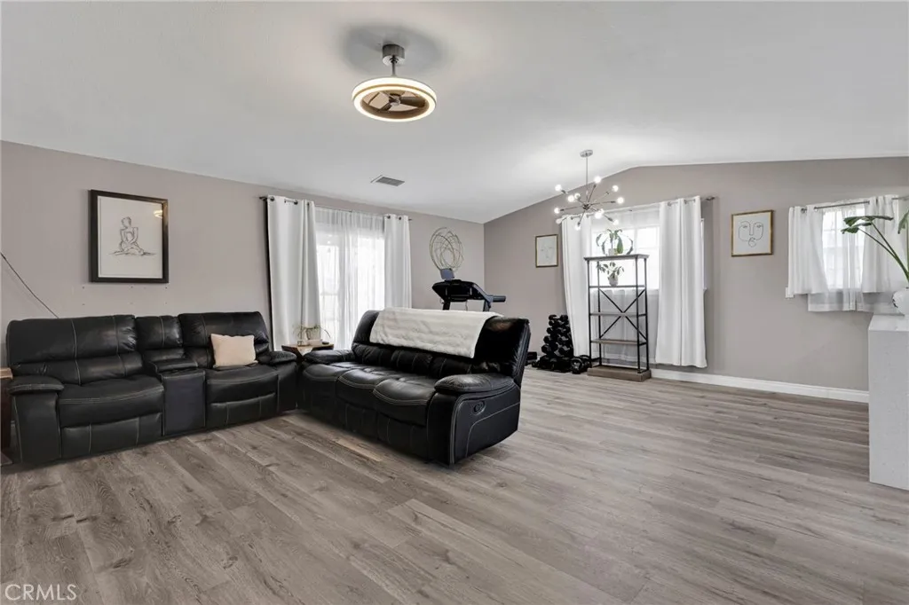Expansive main living area boasts modern wood-look laminate flooring, a neutral color palette, and updated contemporary ceiling light fixtures.