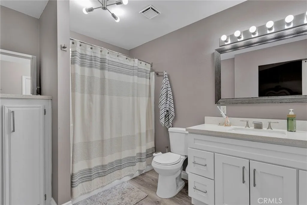 Private primary en-suite bathroom boasts a contemporary white vanity, crisp chrome hardware, updated fixtures, and a bright finish.