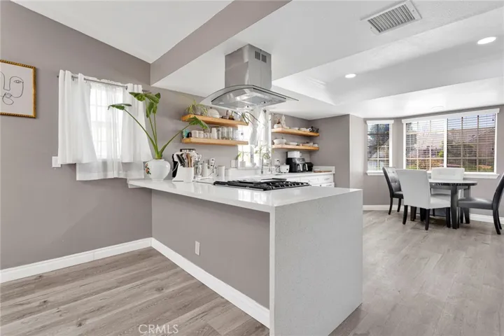 Alternate kitchen perspective showcasing the extensive counter workspace, open layout flow, and clean, high-end design elements.