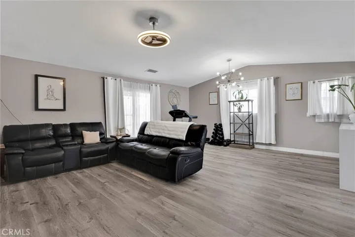 Expansive main living area boasts modern wood-look laminate flooring, a neutral color palette, and updated contemporary ceiling light fixtures.
