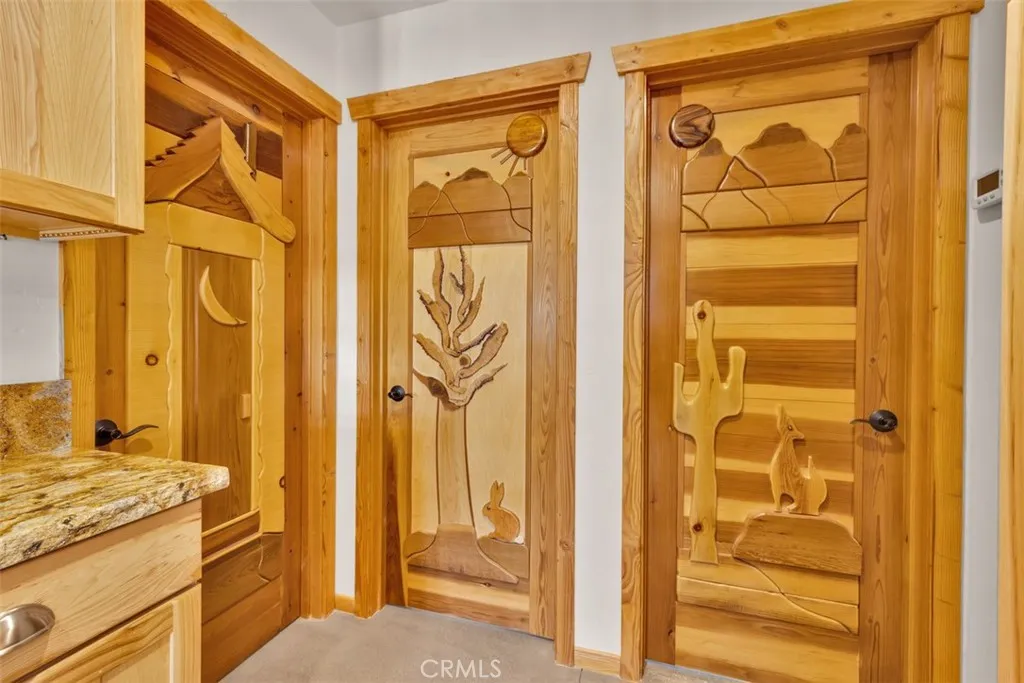 Hallway leading to the guest bathroom, guest bedroom, and primary suite.

All custom wood doors were handcrafted by the seller.