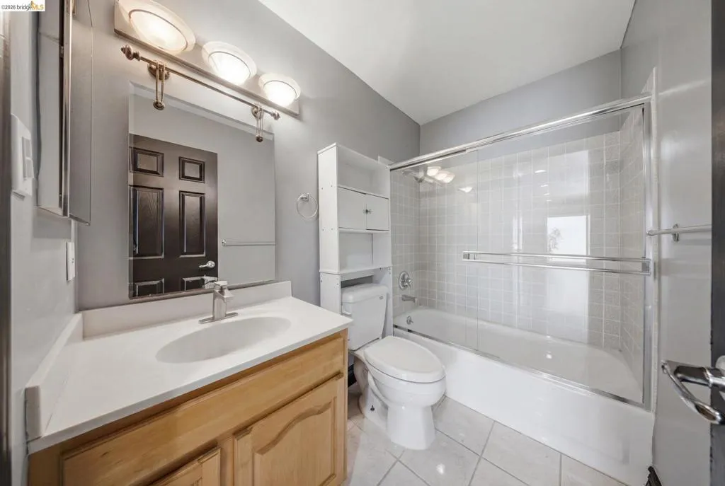 Bathroom featuring a single vanity with wood-finish cabinetry, a contemporary oval sink, and a chrome faucet
