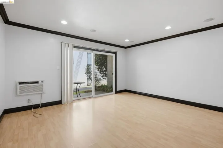 Spacious interior featuring light wood-finish flooring, recessed ceiling lighting, and contrasting dark trim