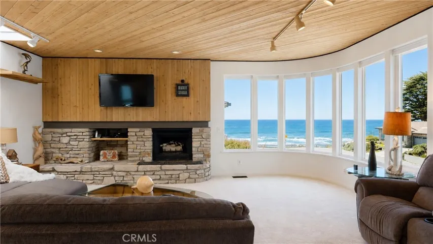 Stone fireplace anchors the ocean-view living room