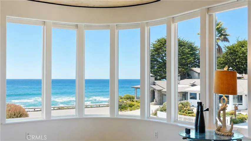 Curved wall of windows framing beautiful ocean views.