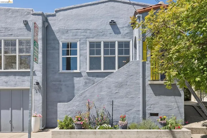 Light blue stucco exterior featuring multiple windows with white trim