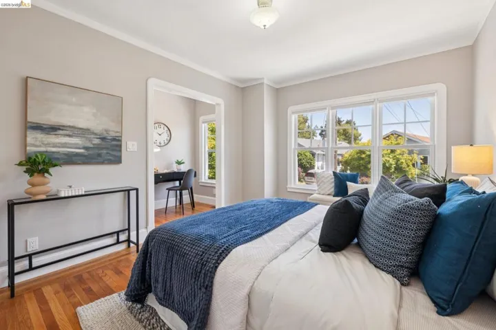 Bedroom with hardwood flooring and a bright window featuring a built-in window seat