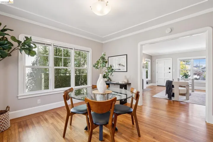 Hardwood flooring extends throughout this room, featuring layered crown molding and a multi-pane window