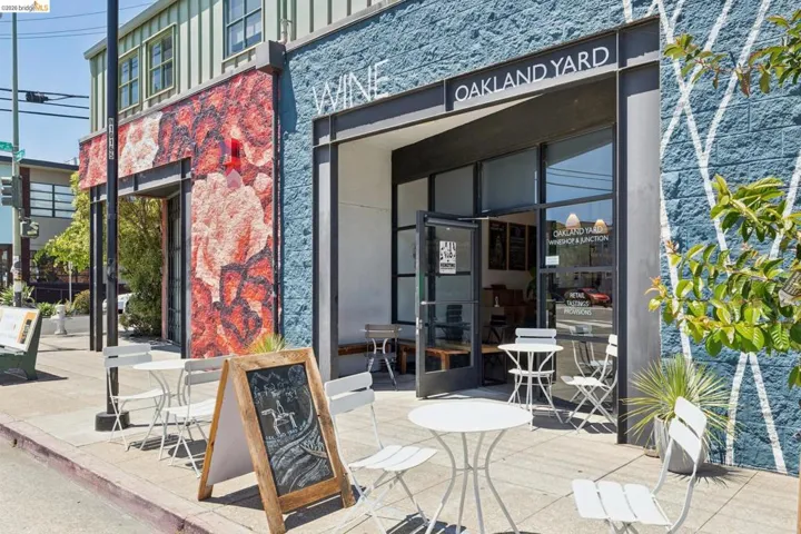 Commercial storefront featuring a prominent entrance with glass doors, a large "Oakland Yard" sign, and a stone facade with a decorative pattern