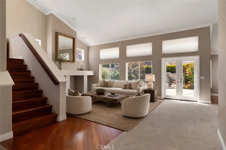 Open family room with soaring ceilings. Digitally enhanced with virtually staged furniture