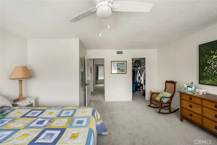 Primary Bedroom with view towards large walk-in closet and hallway/laundry closet.