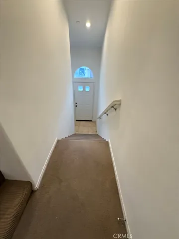 Stairs from the front door that lead up to ledge that turns to stairs to living room