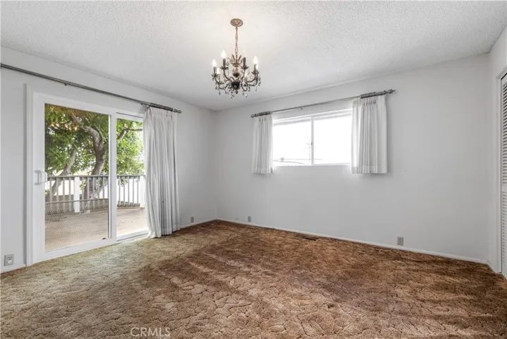 Bathed in natural light, the primary bedroom offers an effortless transition to the outdoor deck, creating a bright, airy space that maximizes your connection to the outdoors.