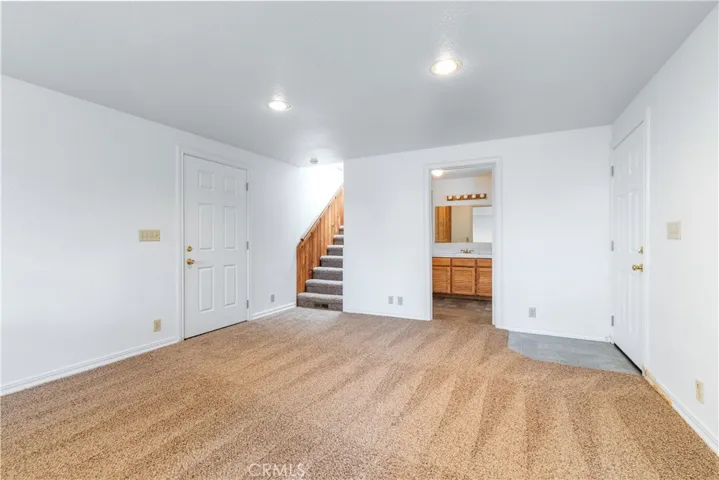 This lower level includes a bright bonus room and a full third bathroom, uniquely equipped with dual entry doors. The exterior access point makes this an ideal setup for a home gym, guest quarters, or a convenient 'mudroom' style bathroom for those returning from the outdoors.