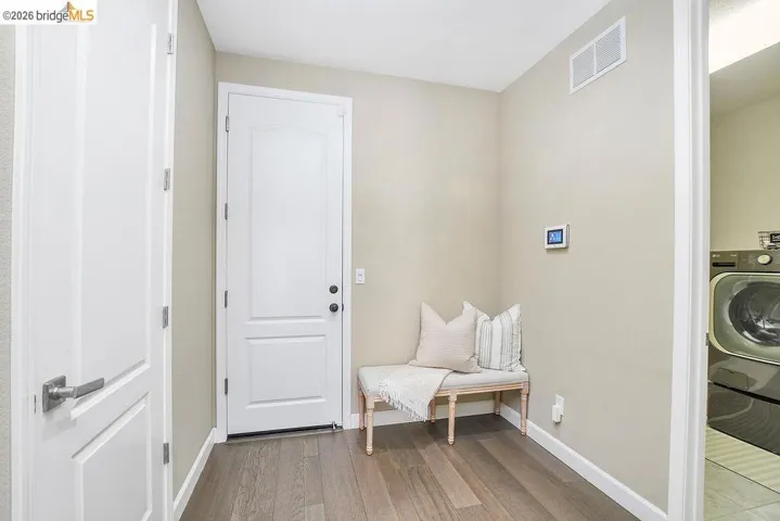 Entryway to the garage featuring wood-finish flooring, a white paneled door, and recessed lighting