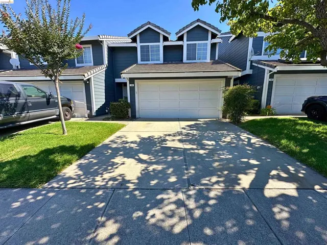 Two-story residence featuring a blue exterior with white trim, a single-car garage, and a concrete driveway