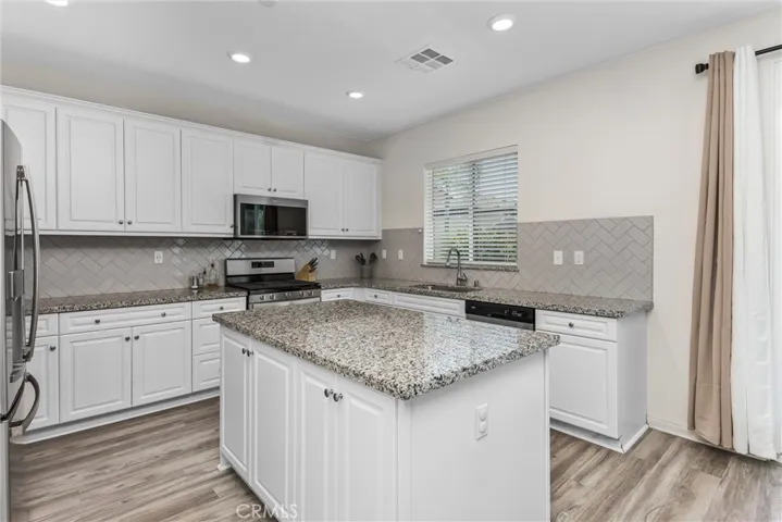 The kitchen also has can lighting & a beautiful tiled backsplash