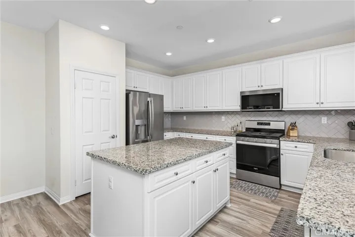 The kitchen features a pantry, island with storage in it, granite countertops, ENERGY Star Qualified appliances