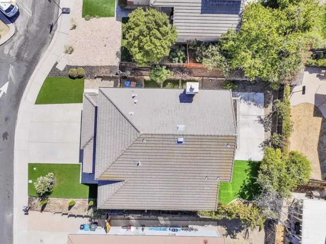 Aerial perspective showcasing a property with a tiled roof, concrete driveway, and artificial turf sections