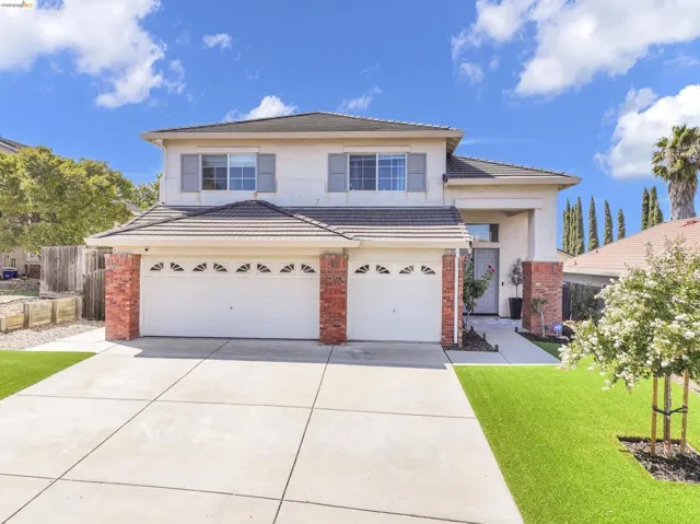 Two-story property featuring a stucco exterior with brick accents