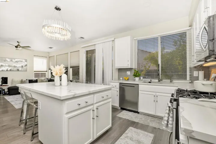 Kitchen island with a light-toned countertop, white cabinetry, and brushed nickel hardware