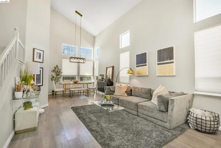 Vaulted ceilings featuring multiple windows and a contemporary linear chandelier