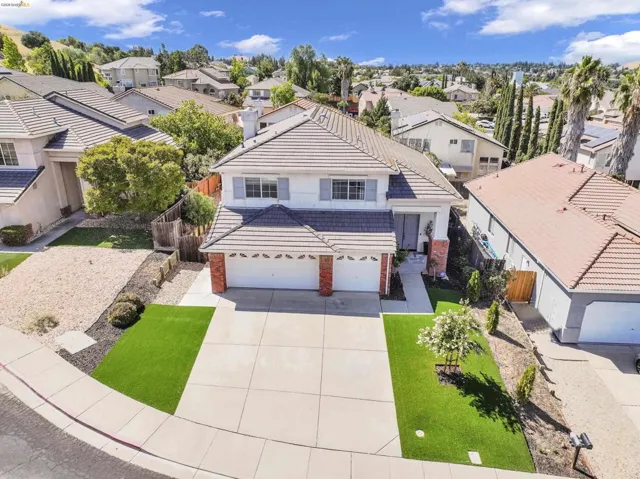 Two-story property featuring a tile roof, brick facade accents, and a three-car garage
