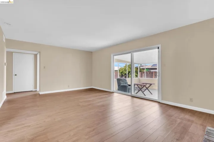 Spacious interior with wood-finish flooring, neutral-toned walls, and white baseboards