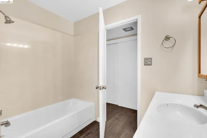 Bathroom featuring a white tub, shower fixture, and a vanity with an integrated sink