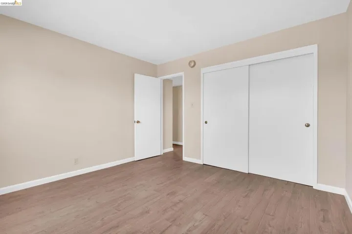 Room featuring wood-finish flooring, neutral wall paint, and white baseboards