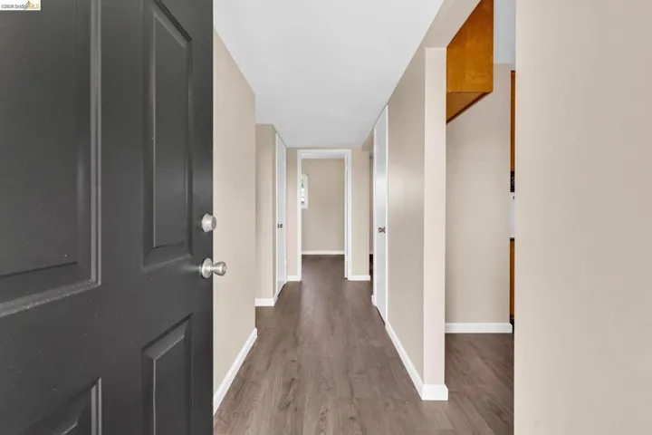 Entryway featuring a dark paneled door, wood-finish flooring, and light neutral wall colors