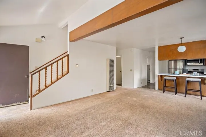 From the front deck, entry door opens to the stairway which leads up to the 2 bedrooms. Each bedroom has their own bathroom. From entry door to the right is the spacious living dining area, breakfast bar, kitchen and laundry room and back door that leads out to the extra 25 Ft. lot parcel.