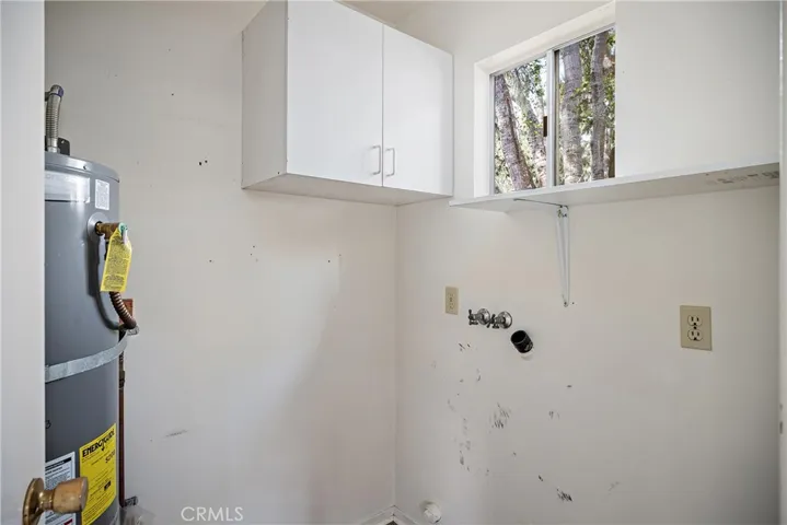 Laundry room with washer/dryer hook-ups and where the water heater is located.
