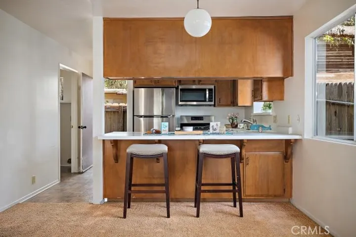 Another view of kitchen...doorway to the left leads to the laundry room and is where the hot water heater is located. Kitchen also has a back door which allows for cross ventilation and leads outside to the additional single lot parcel which is to the left upon exiting.
