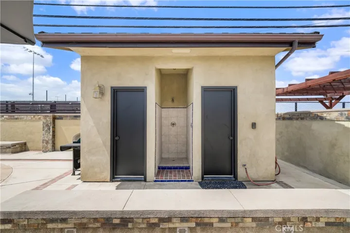Poolside bathroom complete with an open-air shower, and separate changing/storage room
