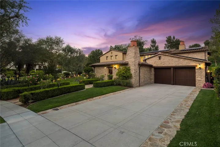 Exterior front with plush landscape and beautiful lighting