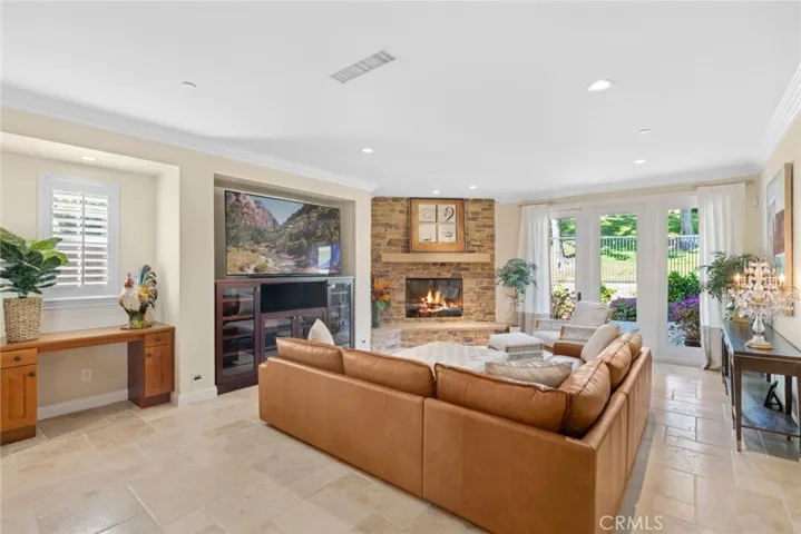 Family room with custom media niche, built in desk facing gorgeous fireplace and backyard
