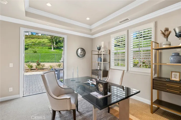 Oversized French doors create seamless indoor-outdoor living, opening to a private backyard w/ample space for entertaining & relaxation