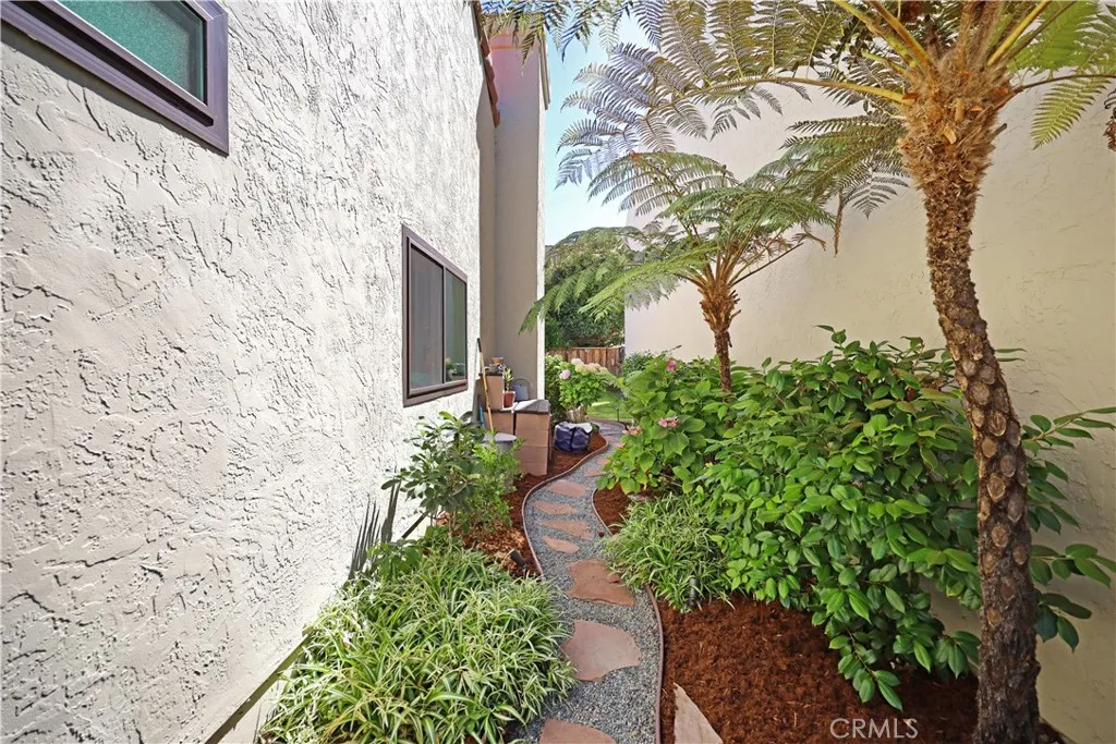 Side yard with lush greenery providing an attractive pathway and additional outdoor space