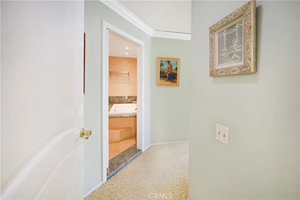 Hallway leading toward the private bedroom wing with a clean, neutral design.