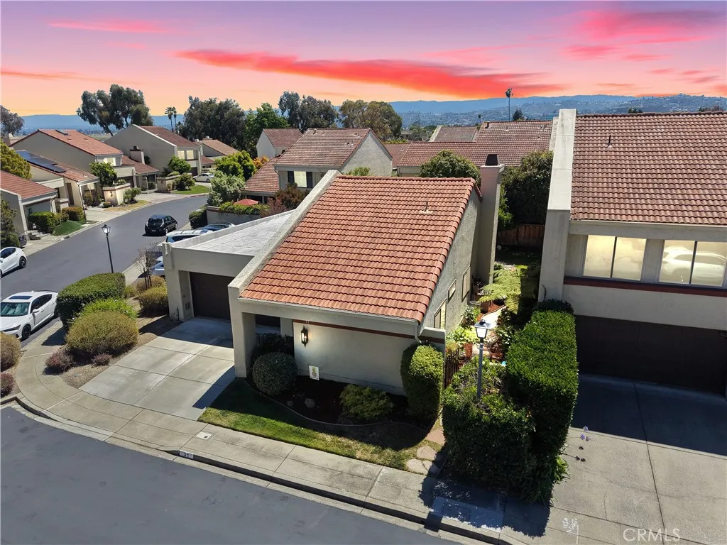 Sunset aerial view highlighting the surrounding community and nearby homes. Virtually Enhanced