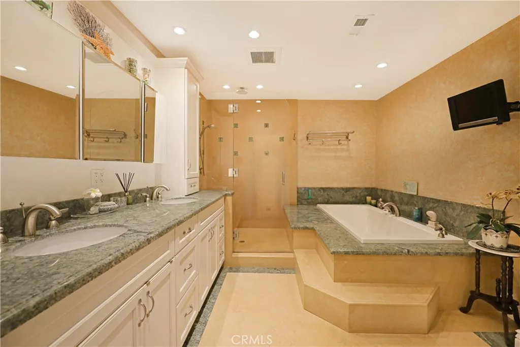 Bathroom complete with a soaking tub, separate vanity, and plenty of room to unwind
