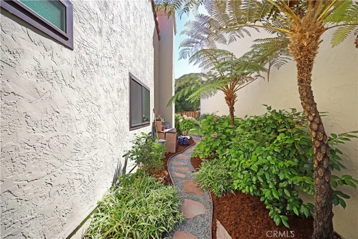 Side yard with lush greenery providing an attractive pathway and additional outdoor space