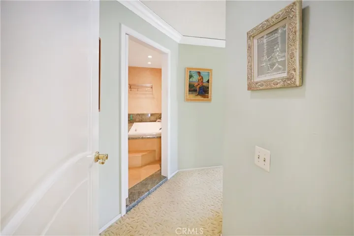 Hallway leading toward the private bedroom wing with a clean, neutral design.